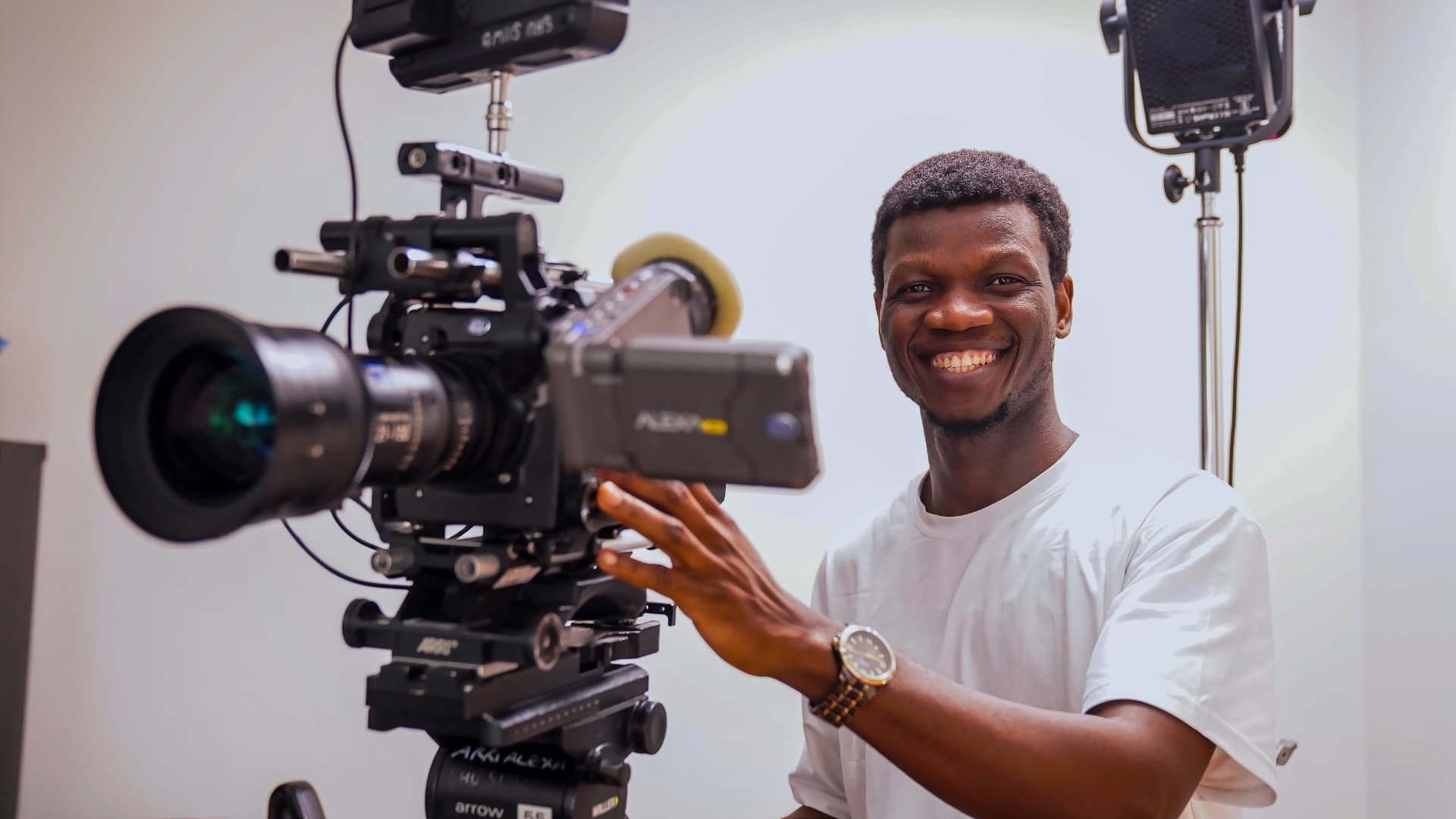 Favour Amuele smiling beside a cinema camera on set